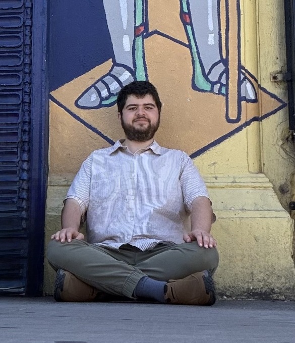 Mohammad sitting beneath a mural of a medieval knight